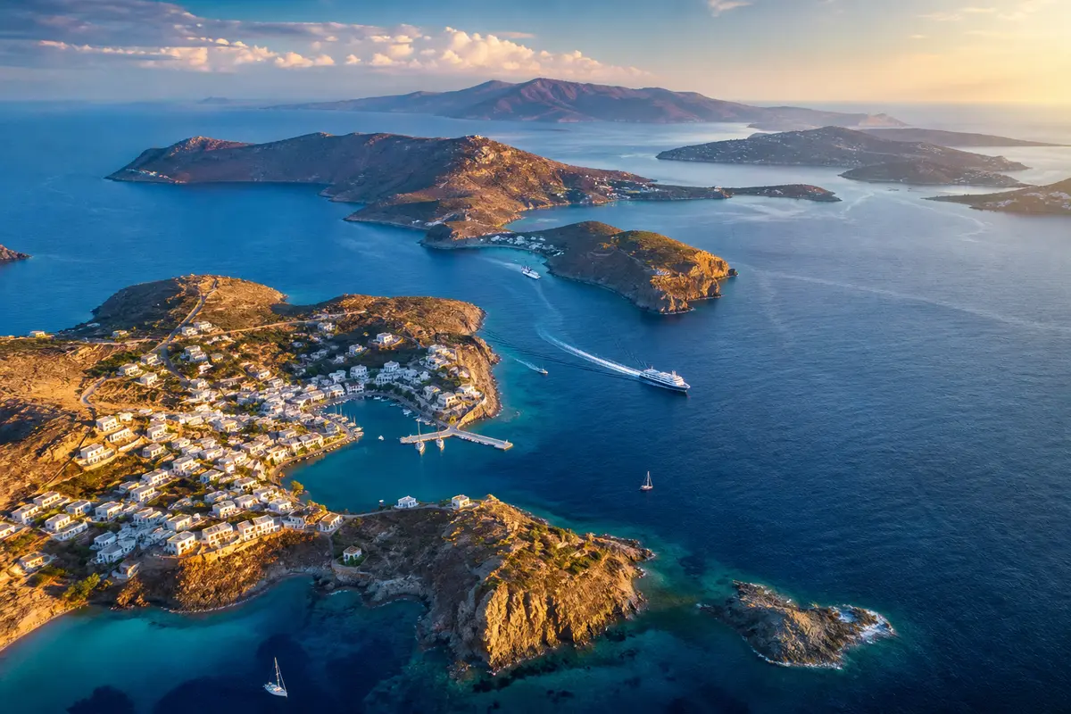 Voyage dans les îles grecques, entre port insulaire et côte rocheuse ; le lieu n’est pas identifié et ne représente pas un itinéraire précis.